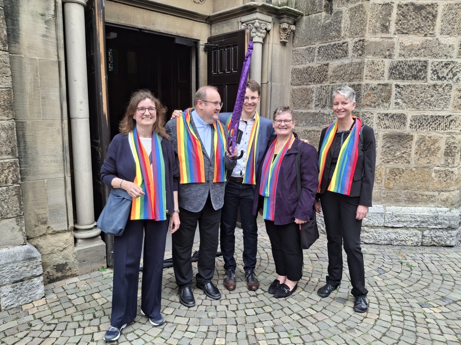 Vier Mitglieder der AG Regenbogenkirche für alle mit Pf. Ullmann bei seinem Abschied in St. Lambertus Mettmann am 13.07.2025